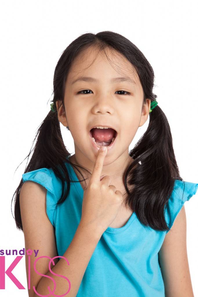 咬手指 Little asian girl point to her mouth isolated on white background