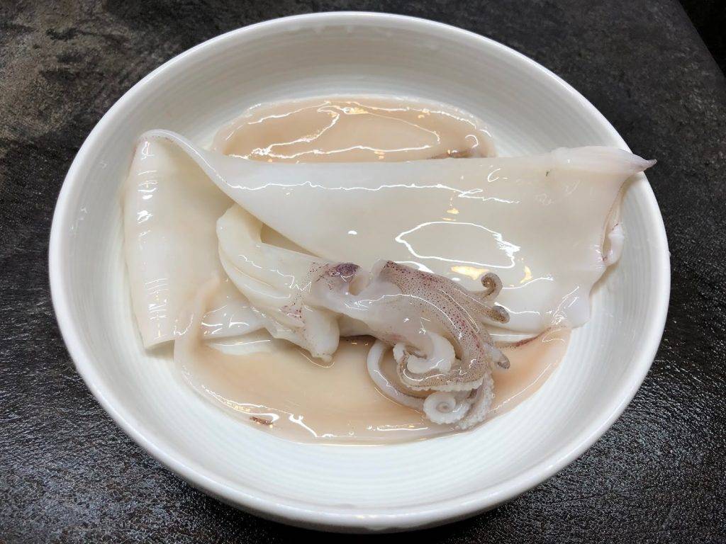 煲仔飯食譜 用手把三角鰭撕下，去除薄膜，把魷魚切件。另把魷魚鬚切成若干的大小。用廚紙或毛巾把水份索乾。