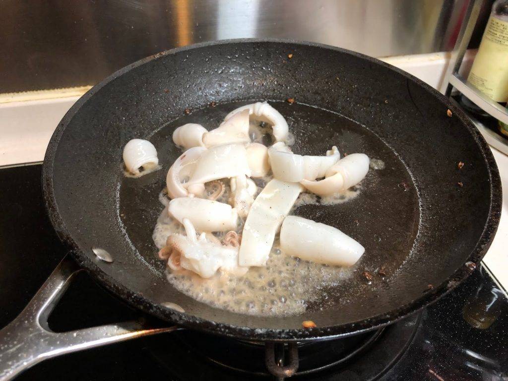 煲仔飯食譜 預備煎鍋，下油，油滾起煙，放入魷魚炒勻至轉白色。