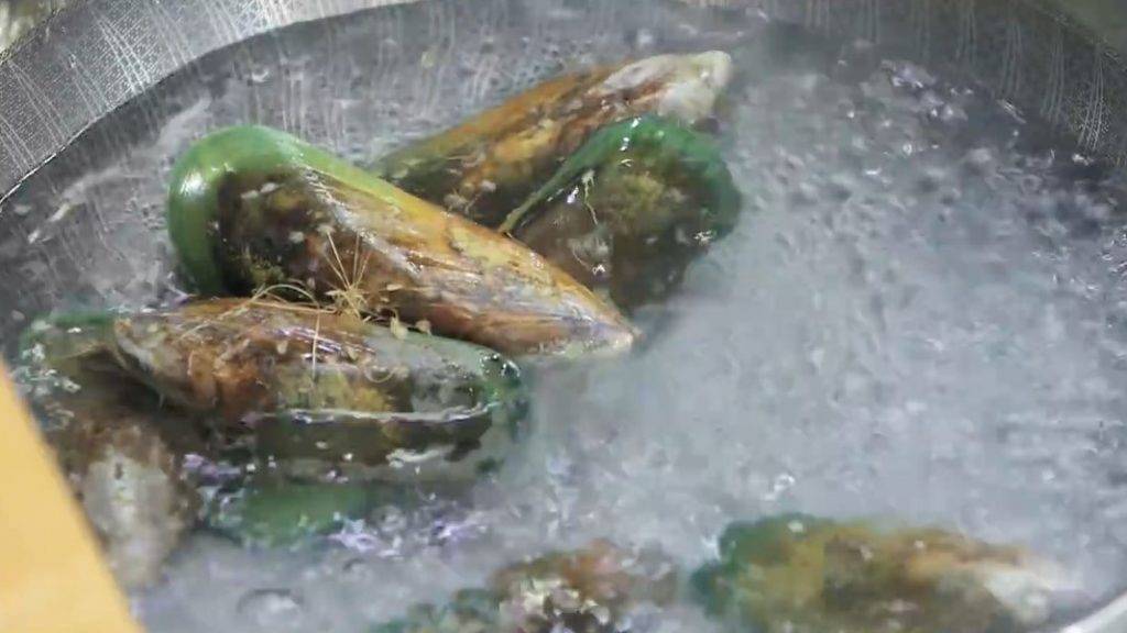 冬菇海味燜節瓜食譜小貼士：如「足絲」難以去除，可先將青口放進滾水煮約3分鐘，待青口開口後把肉取出。（《阿爺廚房》截圖）