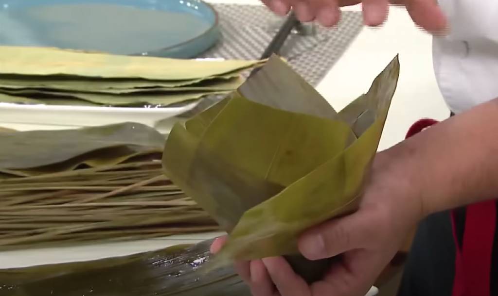 粽子做法 用兩片竹葉包在兩邊，上面放半片竹葉封口。