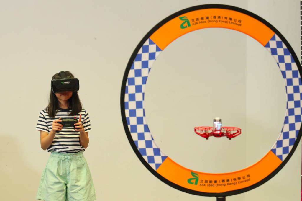暑假好去處 小朋友戴上VR眼鏡以第一身視點FPV)遙控無人機，進行競速比賽