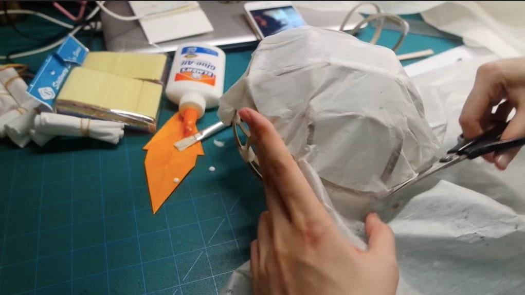 燈籠DIY 6. 用剪刀剪掉多餘的宣紙，再用手按平皺起的邊沿部分，使表面平順。