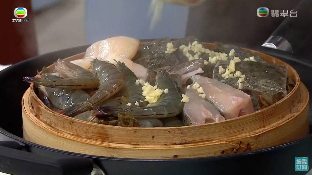 混入1湯匙蒜頭拌勻，隔水再蒸8分鐘成海鮮飯。（圖片來源：TVB《流行都市》截圖）